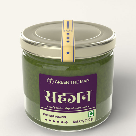 Moringa leaf powder 200 g in a glass jar with a deep purple label and a champagne gold cap, on a plain off-white background.