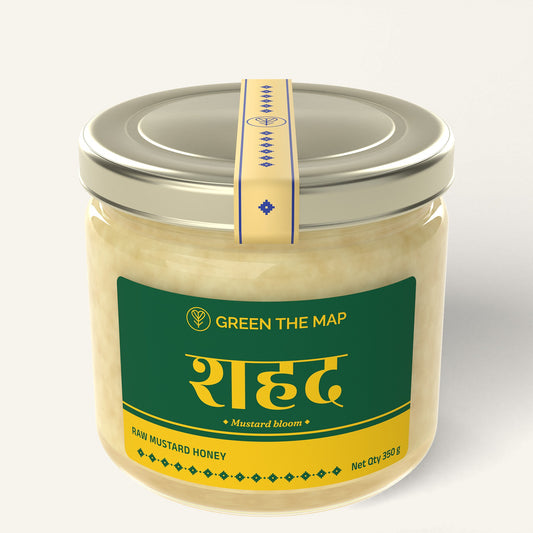 Raw mustard honey 350 g in a glass jar with a green label and a champagne gold cap, on a plain off-white background.